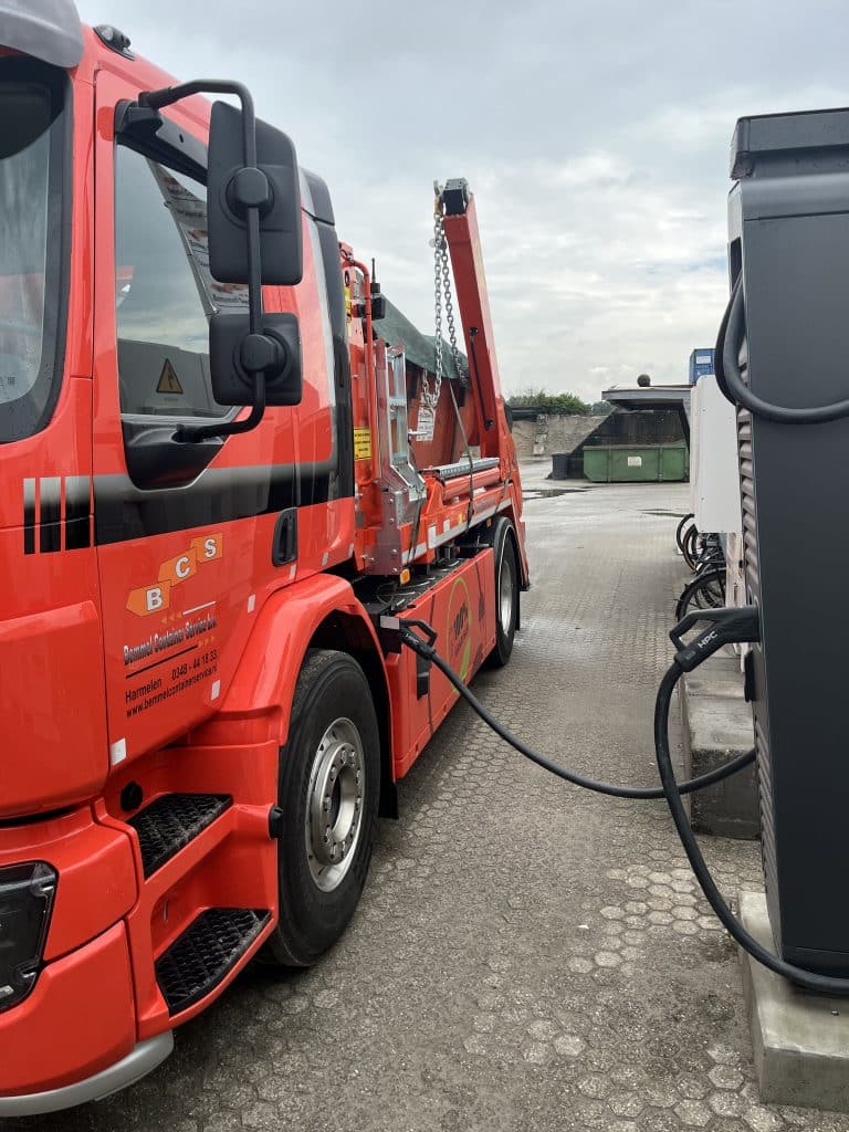 Electric lorry connected to a charging point